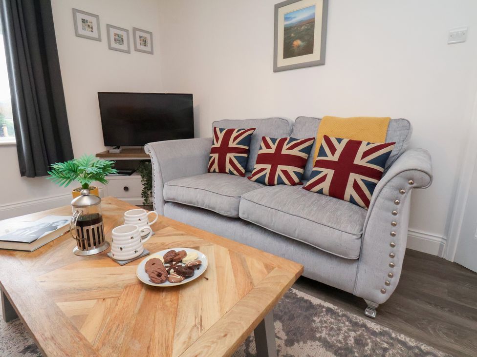 A living room with a sofa and television at Postman’s Lodge in Great Ayton