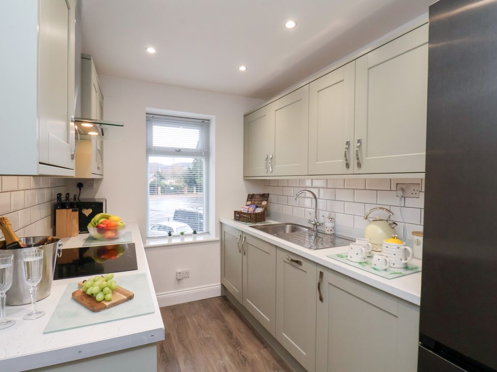 A kitchen with cabinets, sink, and stove at Postman’s Lodge in Great Ayton