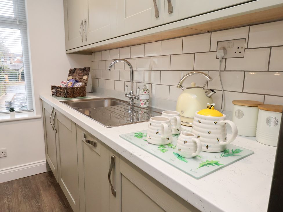 A kitchen with a sink, tea kettle, mugs, and storage jars at Postman’s Lodge in Great Ayton