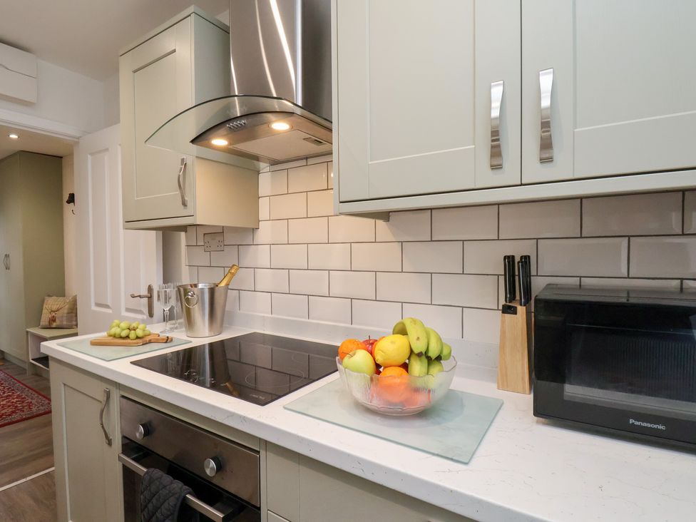 A kitchen with cabinets and stove at Postman’s Lodge in Great Ayton