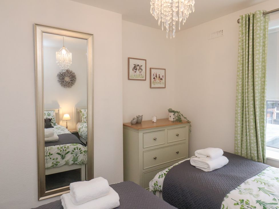 A bedroom with twin beds and a mirror at Postman’s Lodge in Great Ayton