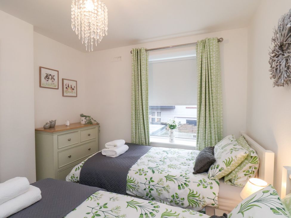 A bedroom with two beds and a dresser at Postman’s Lodge in Great Ayton