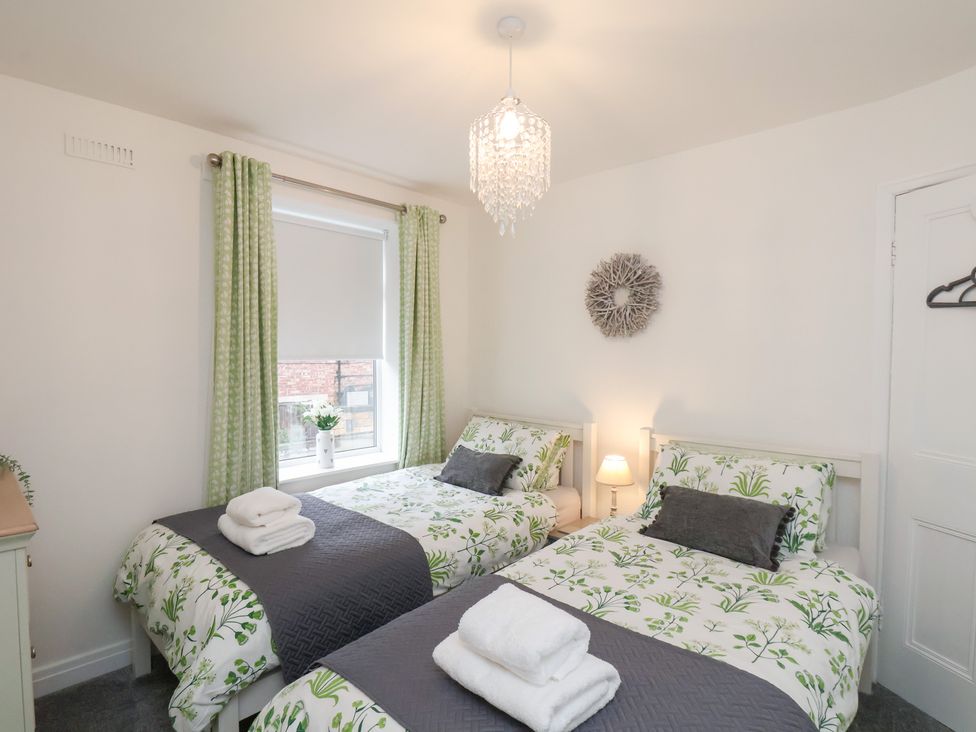 A bedroom with two beds and a window at Postman’s Lodge in Great Ayton