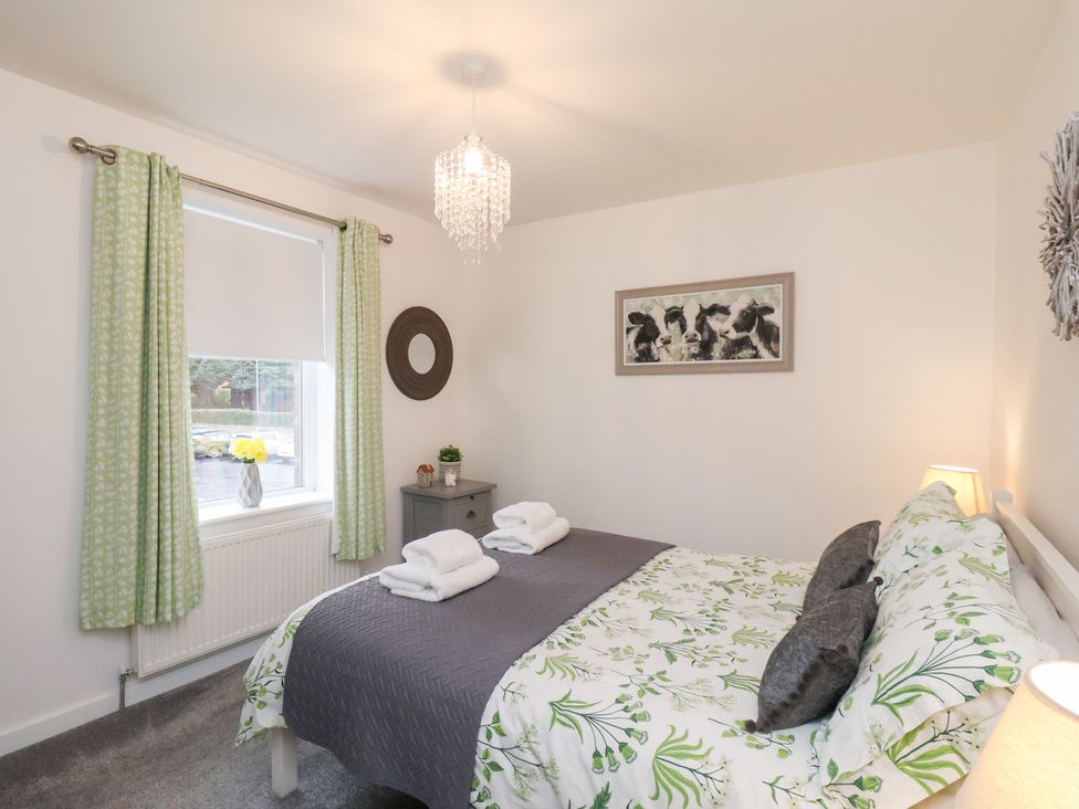 A bedroom with a bed and nightstand at Postman’s Lodge in Great Ayton