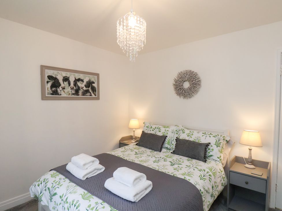 A bedroom with a bed and bedside tables at Postman’s Lodge in Great Ayton