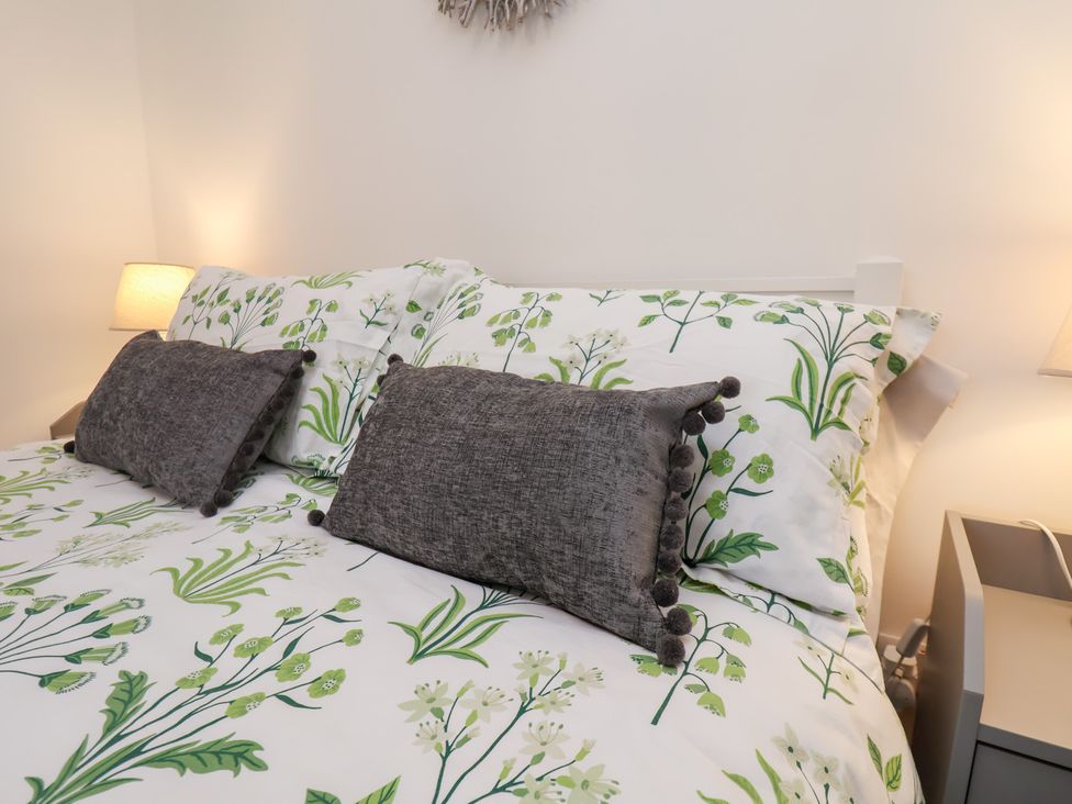 A bedroom with a bed and bedside lamp at Postman’s Lodge in Great Ayton