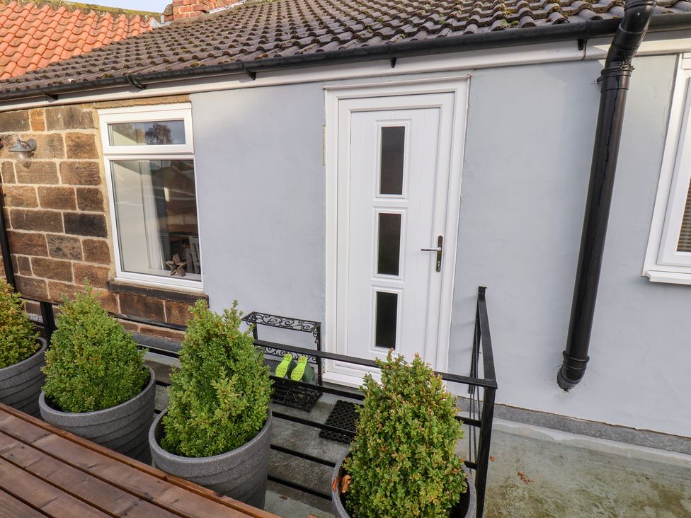 A door and window with planters in front at Postman’s Lodge in Great Ayton