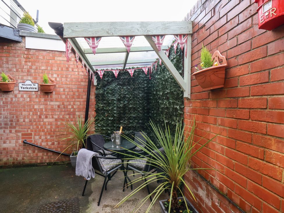 An outdoor seating area with plants and a table at Postman’s Lodge in Great Ayton