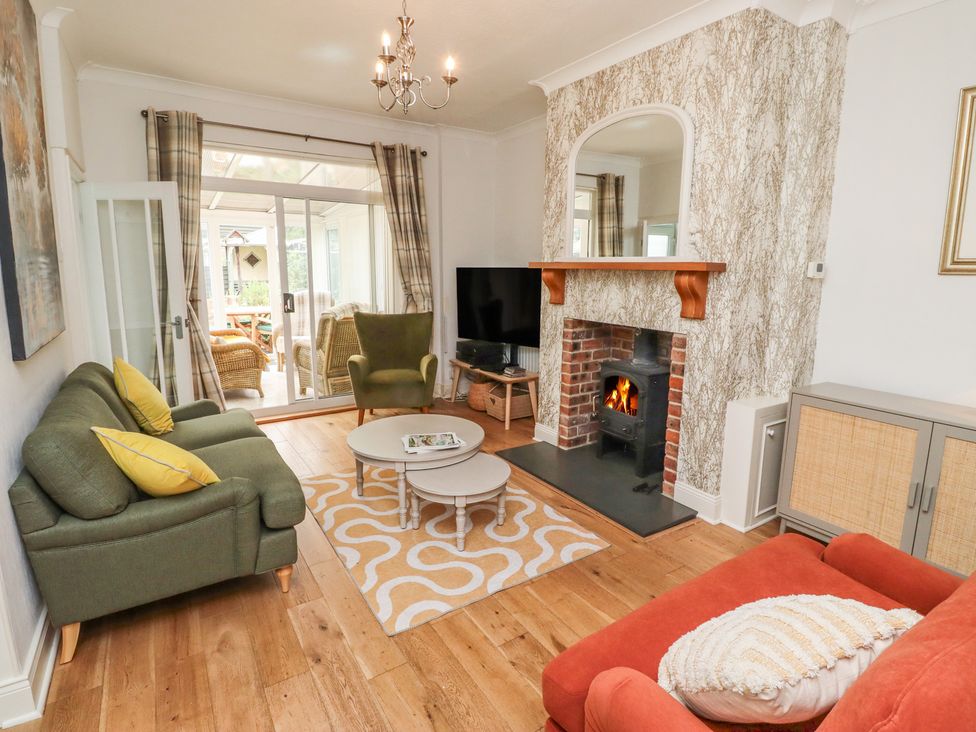 A living room with a sofa, armchair, coffee table, and fireplace at 5 Jackson Terrace, Morpeth