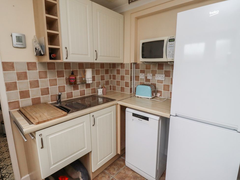 A kitchen with a sink, refrigerator, toaster, and microwave at 5 Jackson Terrace in Morpeth