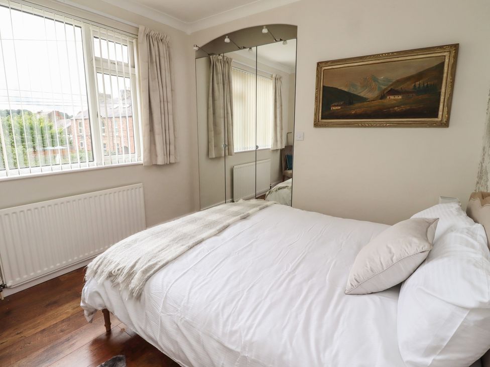 A bedroom with a bed and a wardrobe at 5 Jackson Terrace in Morpeth