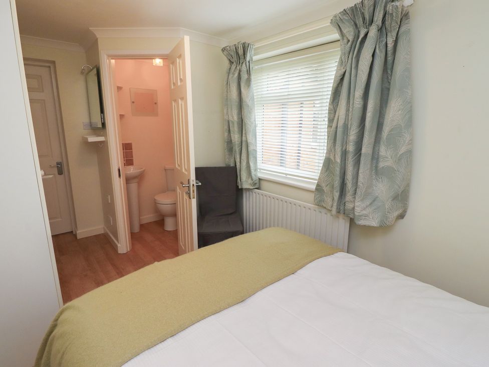 A bedroom with a bed and adjoining bathroom at 5 Jackson Terrace in Morpeth
