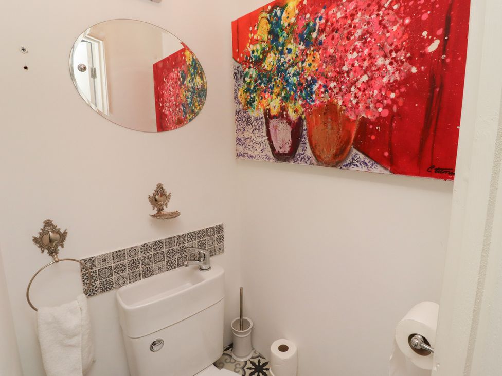 A bathroom with a toilet and artwork at 5 Jackson Terrace in Morpeth
