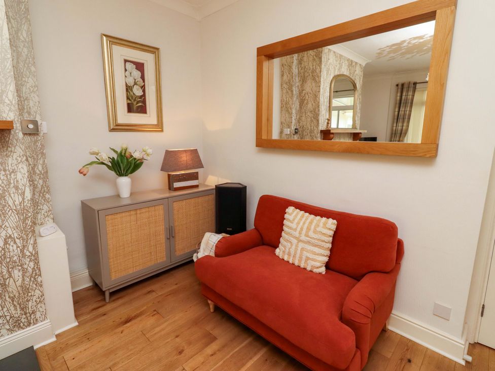 A living room with a sofa and a lamp at Rose Briar Cottage in Morpeth