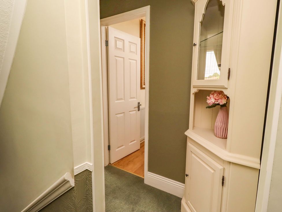 A hallway with a cabinet and a door at Rose Briar Cottage in Morpeth