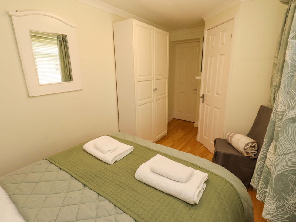 A bedroom with a bed and towels at Rose Briar Cottage Morpeth