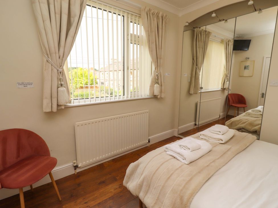 A bedroom with a bed and towels at Rose Briar Cottage in Morpeth