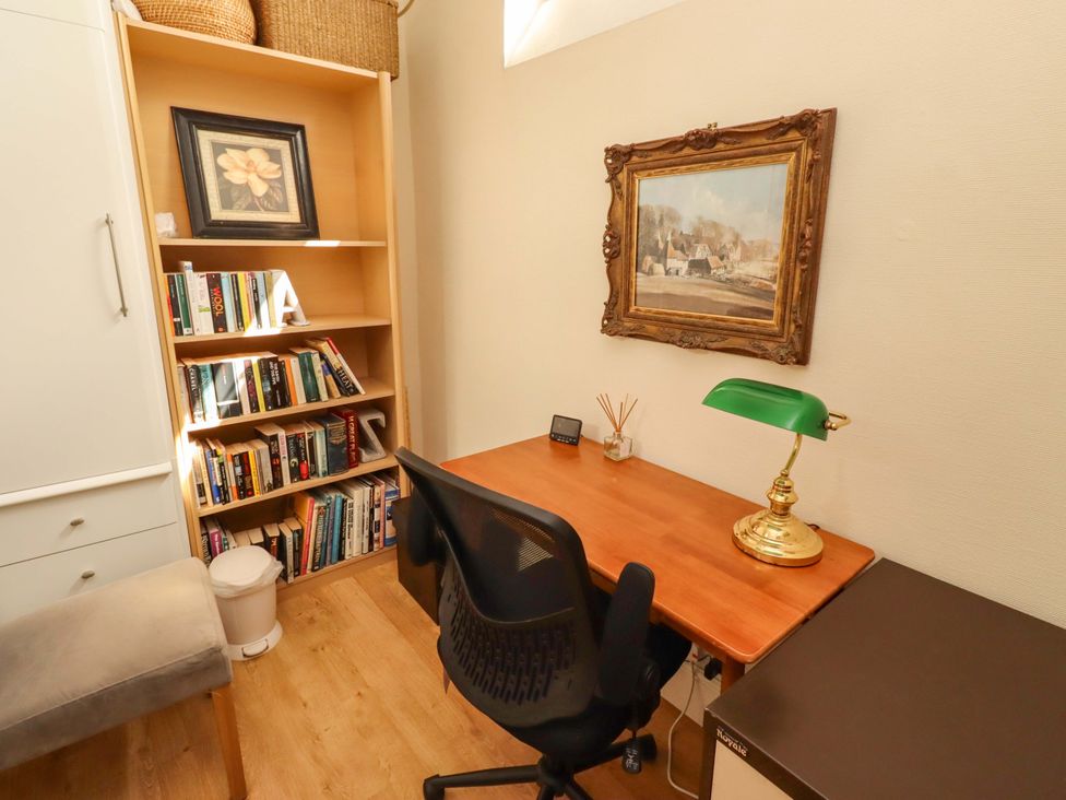 An office with a desk, chair, and bookshelf at Rose Briar Cottage in Morpeth