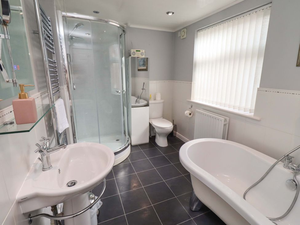 A bathroom with a shower, bathtub, toilet, and sink at Rose Briar Cottage in Morpeth