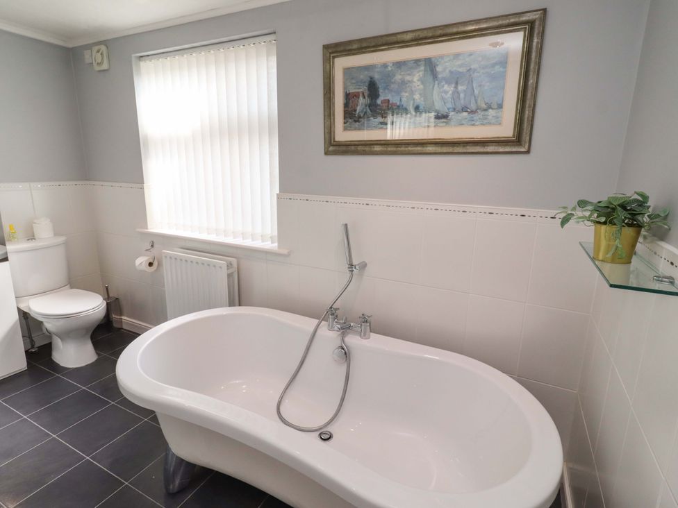 A bathroom with a bathtub and toilet at Rose Briar Cottage Morpeth