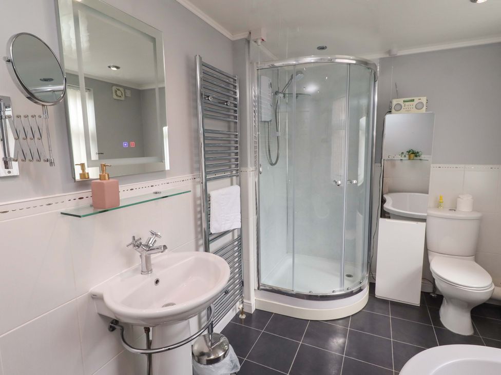 A bathroom with a shower, sink, and toilet at Rose Briar Cottage in Morpeth