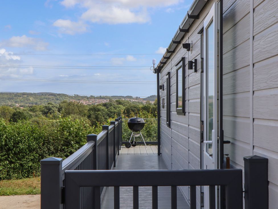 A deck with a barbecue at Maple Lodge in Teigngrace near Kingsteignton