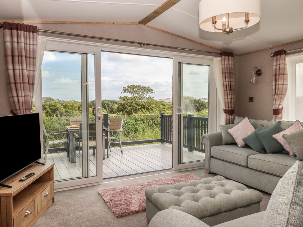 A living room with a sofa and television at Maple Lodge Teigngrace near Kingsteignton