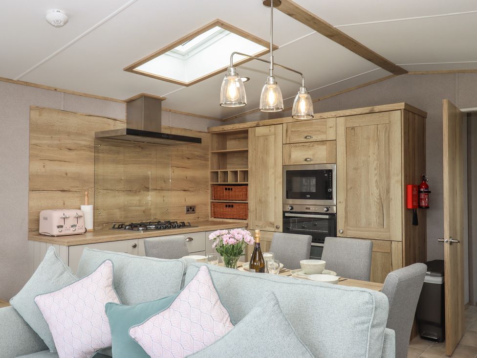 A kitchen with dining area and appliances at Maple Lodge Teigngrace near Kingsteignton