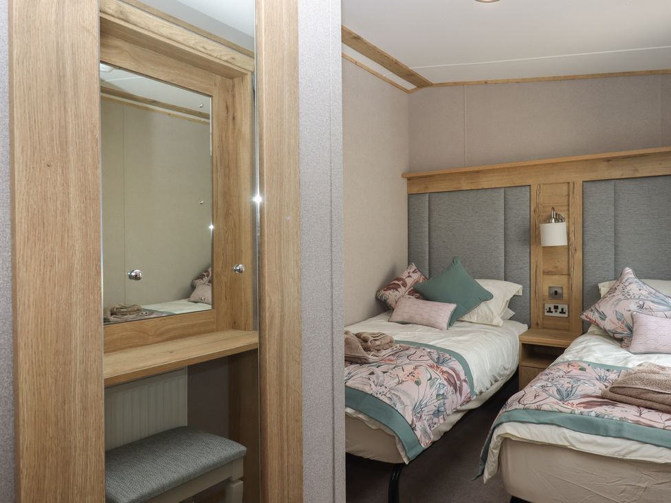 A bedroom with two beds and a mirror at Maple Lodge Teigngrace near Kingsteignton