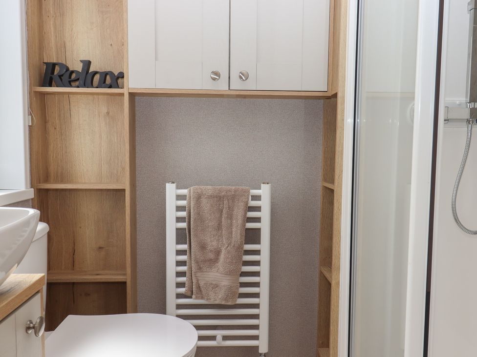 A bathroom with a sink and a towel rack at Maple Lodge Teigngrace near Kingsteignton