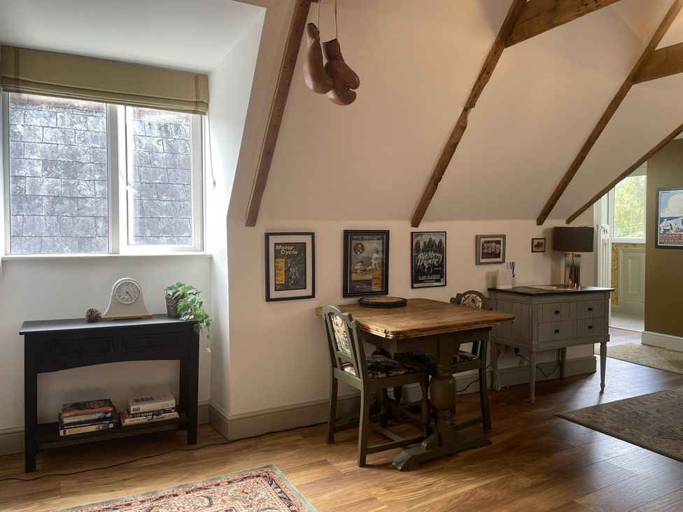 A dining area with a wooden table and chairs at Queensbury Loft in Par