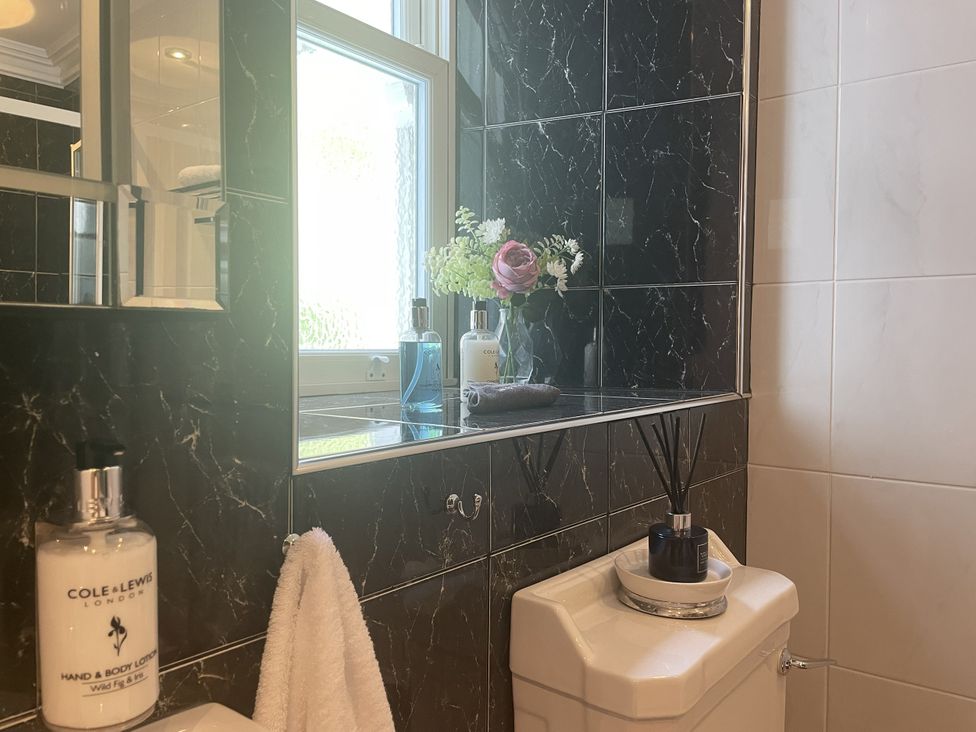 A bathroom with a mirror, toilet, and a window at DeCressy Apartment in Par