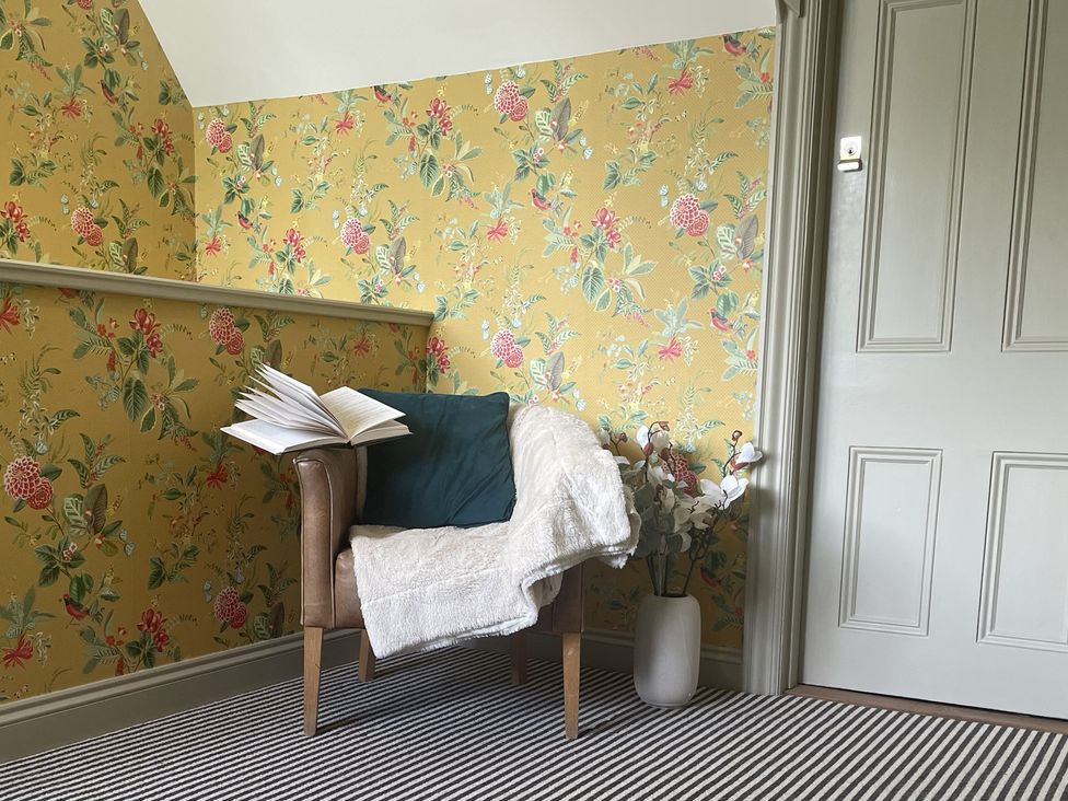 A sitting room with an armchair and an open book at DeCressy Apartment in Par
