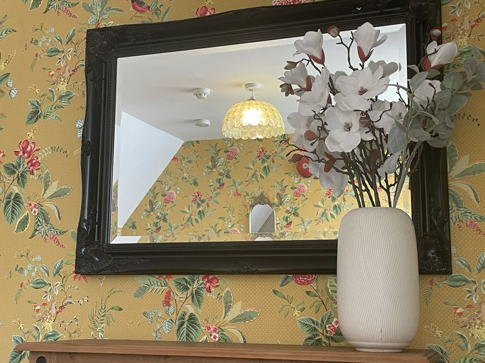 A living room with a mirror and flower vase at DeCressy Apartment in Par