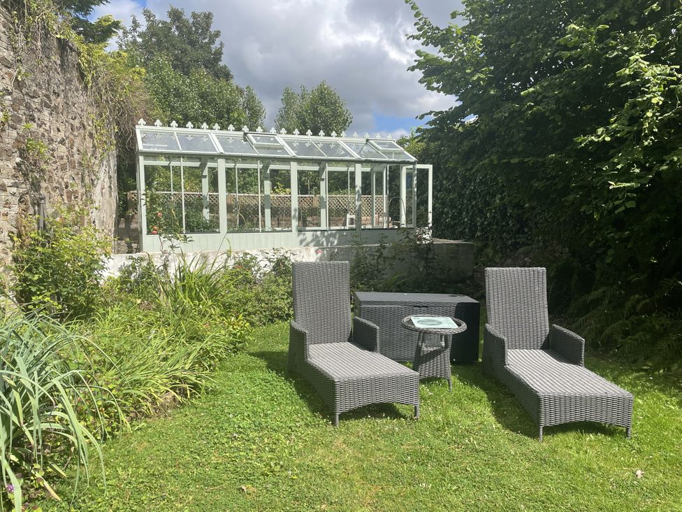 A garden with lounge chairs and a greenhouse at DeCressy Apartment in Par