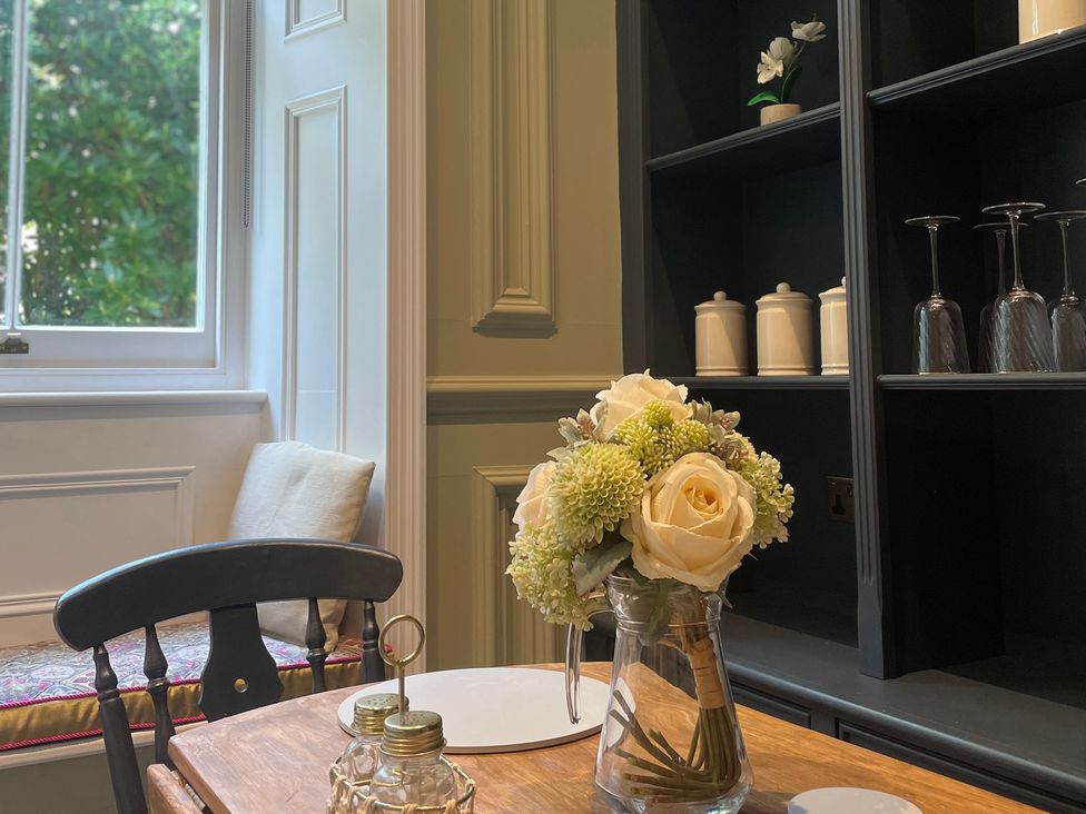 A dining room with table and flowers at Garden Apartment in Par