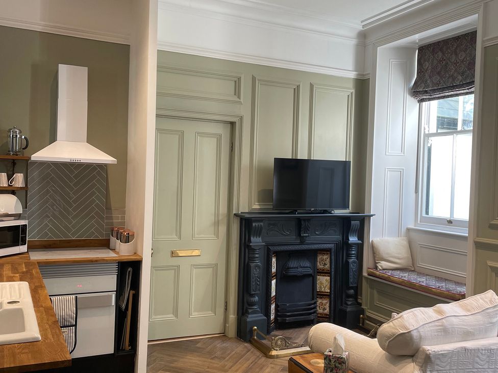 A living room with a television and fireplace at Garden Apartment in Par