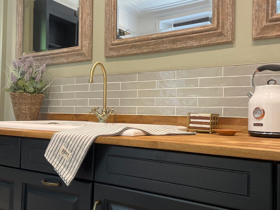 A kitchen countertop with a sink and utensils at Garden Apartment, Par