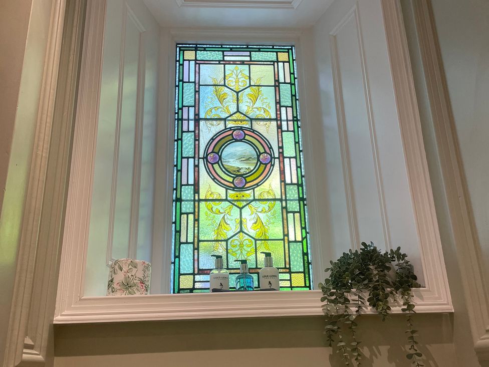A stained glass window with bottles and plants at Garden Apartment in Par