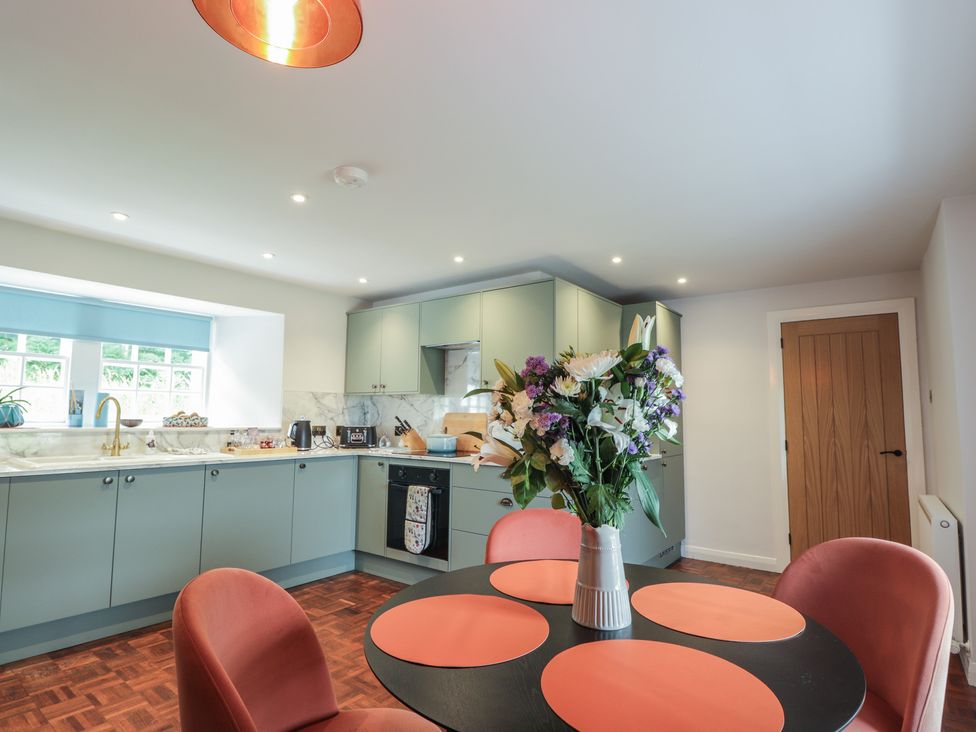 A kitchen with a dining table and flowers at Sron Dubh Achnasheen