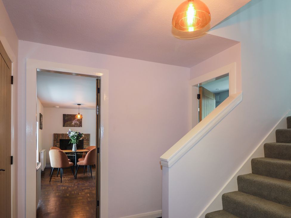 A hallway with a staircase and light fixture at Sron Dubh Achnasheen