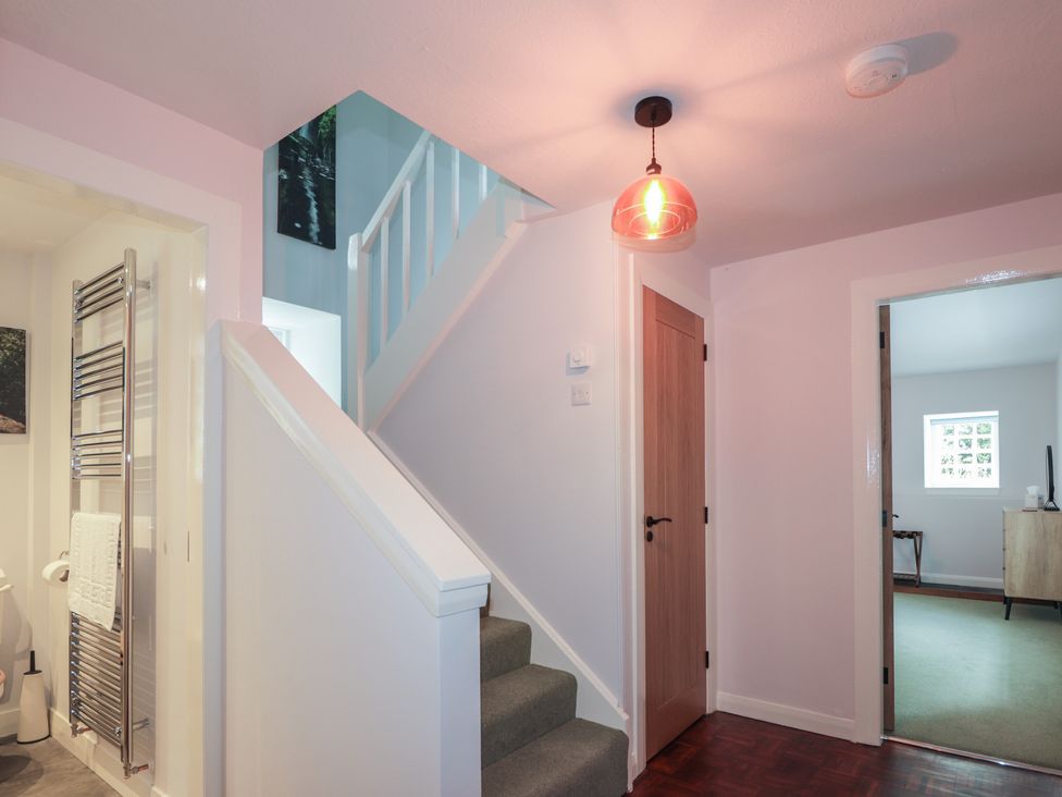 A hallway with a staircase and light fixture at Sron Dubh Achnasheen
