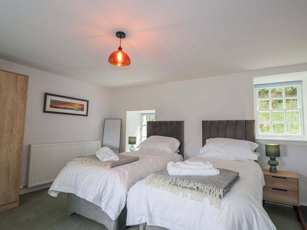 A bedroom with two beds and a table at Sron Dubh Achnasheen