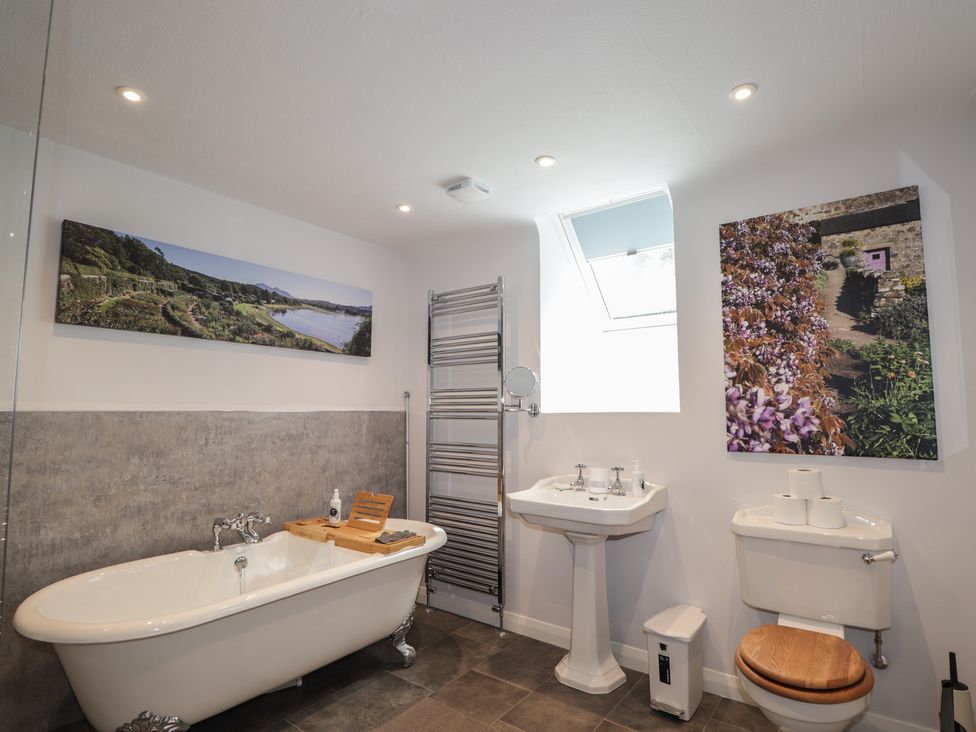 A bathroom featuring a bathtub, toilet, sink, and towel radiator at Sron Dubh in Achnasheen