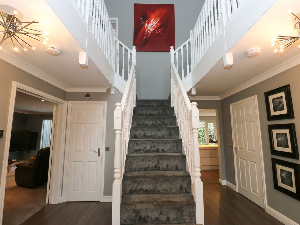 A hallway with staircase and wall art at 20 Overland Crescent in Apperley Bridge