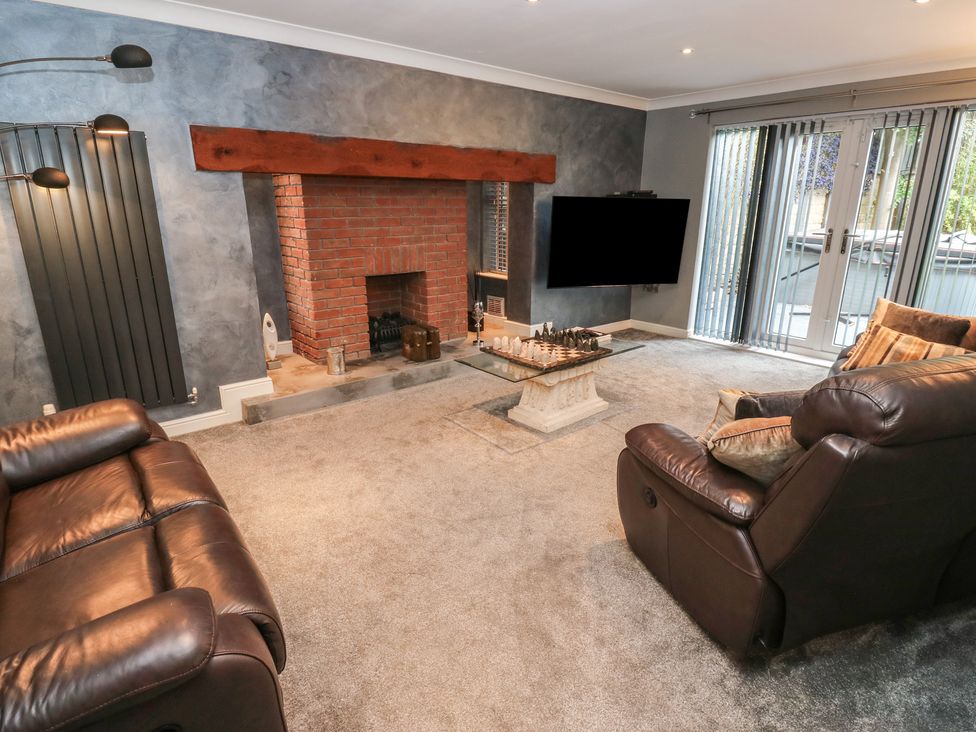 A living room with a fireplace and sliding doors at 20 Overland Crescent in Apperley Bridge