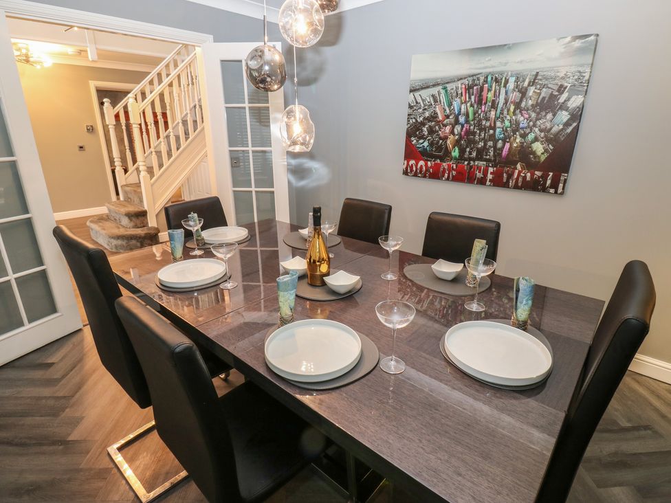A dining room with a table set for dinner at 20 Overland Crescent in Apperley Bridge
