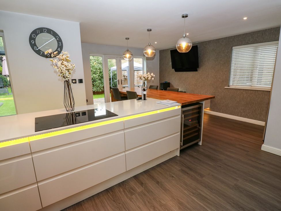 A kitchen with a stove and seating area at 20 Overland Crescent in Apperley Bridge
