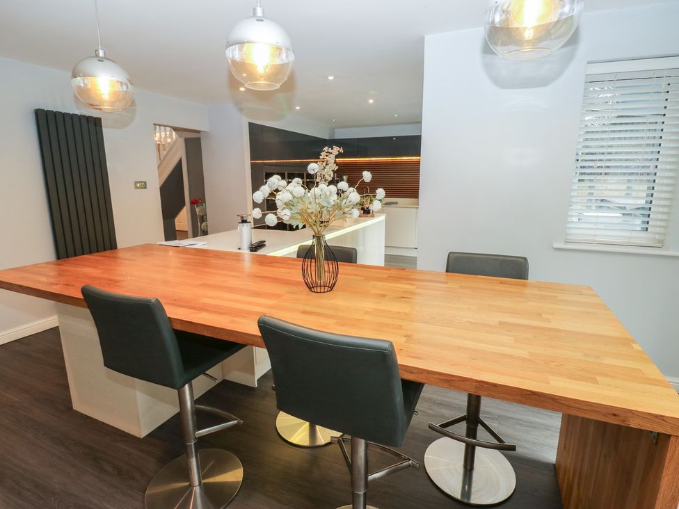 A kitchen with a wooden table and stools at 20 Overland Crescent in Apperley Bridge