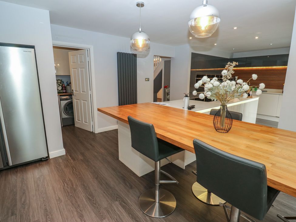A kitchen with a countertop and bar stools at 20 Overland Crescent in Apperley Bridge